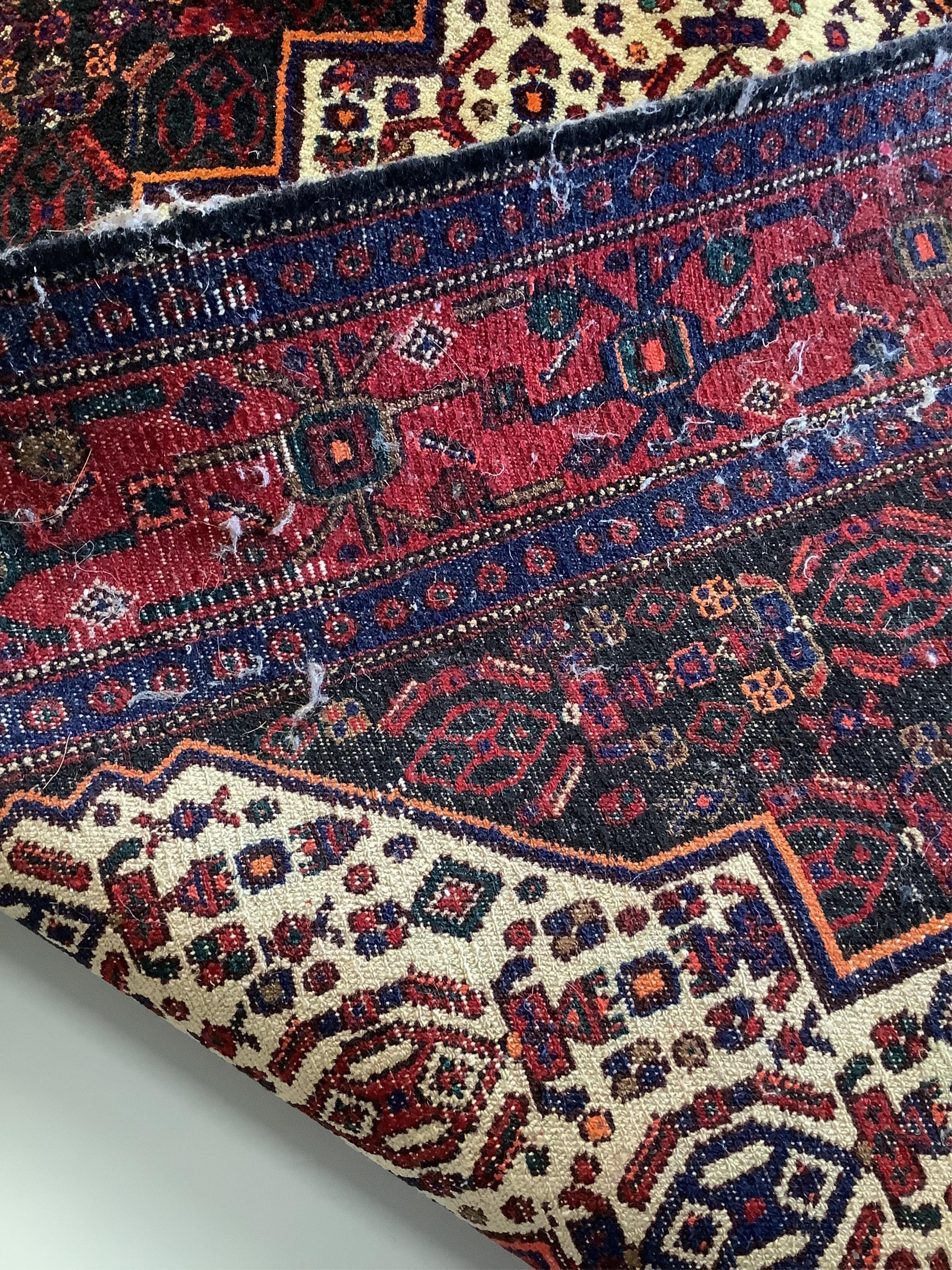 A Shiraz red ground rug, 150 x 120cm. Condition - fair